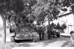 Frankreich.- Panzer IV und LKW der Luftwaffe mit Soldaten auf einer Straße unter Bäumen in einer Ortschaft; PK KBZ OB West — Frankreich