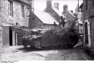 Frankreich.- Deutsche Soldaten mit getarntem Sturmgeschütz III in Ortschaft; KBZ Ob. West — Frankreich