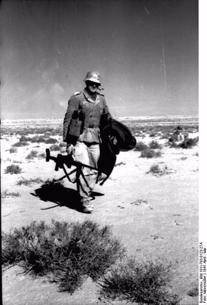 Nordafrika.- Soldat beim Tragen einer Panzerbüchse durch die Wüste; PK Afrika — Nordafrika