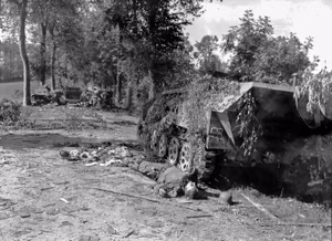 Aftermath of bombardment of Mortain in front of the station of Mortain-Le-Neufbourg, in the foreground a half-track vehicle Sdkfz of the 2.SS-Panzer division “Das Reich”, in the foreground the corpse of a dead German soldier.