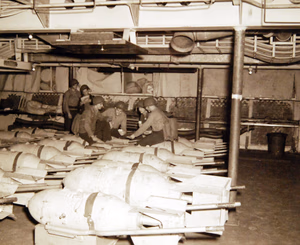 80-G-30263: Operation Torch, November 1942. USS Ranger (CV-4), bombs onboard during the Amphibious Force invasion. Bluejackets are guarding bombs. Standing left to right: Seaman First Class J.B. Williams; Aviation Machinist’s Mate Third Class M.S. Beaker. Seated. Seaman First Class J.A. Bagnera; Aviation Machinist’s Mate M. H. Angrist; Seaman Second Class E.M. Dembrowski; and Seaman Second Class D.G. Dinges. Official U.S. Navy Photograph, now in the collections of the National Archives. (2017/06/06).