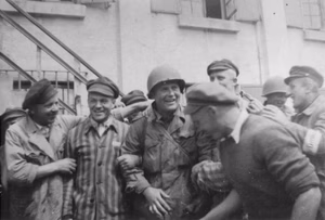 An American Soldier is surrounded by survivors at the newly liberated Dachau concentration camp, April 29, 1945 in Dachau, Germany. American Soldiers of the U.S. 7th Army, including members of the 42nd Infantry and 45th Infantry and 20th Armored Divisions participated in the camp’s liberation. (U.S. Army photo courtesy of the U.S. Holocaust Memorial Museum)