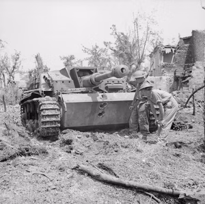British troops examine a knocked-out German StuG III assault gun near Cassino, Italy, 18 May 1944. Troops examine a knocked-out German StuG III assault gun near Cassino, 18 May 1944. Two 75mm AP rounds from a Sherman tank have neatly penetrated its front armour.