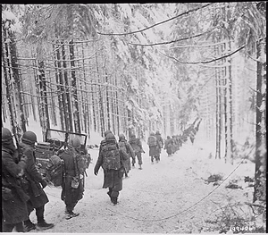 American soldiers of the 289th Infantry Regiment march along the snow covered road on their way to cut off the Saint Vith Houffalize road in Belgium. NARA 531244.gif