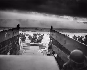 Easy Red Sector, Omaha Beach, Normandy, France — 6 June 1944, approximately 07:40. Soldiers of Company E, 16th Infantry Regiment, 1st Infantry Division disembark from a Coast Guard-crewed LCVP during the D-Day landings. Photograph by Robert F. Sargent.