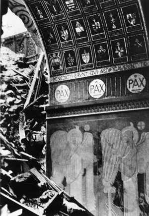 For documentary purposes the German Federal Archive often retained the original image captions , which may be erroneous, biased, obsolete or politically extreme . Monte Cassino, Basilika, Zerstörungen So wüteten die anglo-amerikanischen Bomber und Artillerie-Geschosse im Kloster Monte Cassino. Die Gewölbe der wundervoll ausgeschmückten Basilika sind eingestürzt und haben die herrlichen Mosaikbilder und Wandmalereien unter sich begraben. Ein stehengebliebener Pfeiler klagt an: "Pax!" (Friede). PK-Aufnahme Kriegsberichter Czirnich 30.3.44 [Herausgabedatum] (1145)