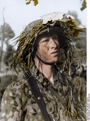 This is a retouched picture , which means that it has been digitally altered from its original version. Modifications: recolored . The original can be viewed here: Bundesarchiv Bild 146-1977-143-25, Frankreich, SS-Grenadier.jpg : . Modifications made by Ruffneck'88 . Frankreich, SS-Grenadier ( ) Photographer Zschäckel, Friedrich Archive description InfoField Description provided by the archive when the original description is incomplete or wrong. You can help by reporting errors and typos at Commons:Bundesarchiv/Error reports . Frankreich, Normandie.- Porträt eines Soldaten der SS-Grenadier-Panzerdivision, "Hitler Jugend" mit getarntem Stahlhelm Title Frankreich, SS-Grenadier Original caption For documentary purposes the German Federal Archive often retained the original image captions , which may be erroneous, biased, obsolete or politically extreme . Invasionsfront Das Gesicht des Grenadiers der Panzerdivision "Hitler-Jugend" an der normannischen Invasionsfront. Foto: SS-Kriegsberichter Zschäkel Depicted place France Date 21 June 1944 date QS:P571,+1944-06-21T00:00:00Z/11 Collection German Federal Archives Native name Das Bundesarchiv Parent institution Federal Government Commissioner for Culture and Media Location Koblenz (headquarters) Coordinates 50° 20′ 32.71″ N, 7° 34′ 21.22″ E Established 1946 Website www.bundesarchiv.de Authority file : Q685753 VIAF : 137346469 ISNI : 0000000405552728 LCCN : n92025526 NLA : 36455393 OSM : 1844909 WorldCat institution QS:P195,Q685753 Current location Sammlung von Repro-Negativen (Bild 146) Accession number Bild 146-1977-143-25 Source This image was provided to Wikimedia Commons by the German Federal Archive (Deutsches Bundesarchiv) as part of a cooperation project . The German Federal Archive guarantees an authentic representation only using the originals (negative and/or positive), resp. the digitalization of the originals as provided by the Digital Image Archive . Other versions This image has an extracted file : Eichenlaubmuster (detail of uniform).jpg .