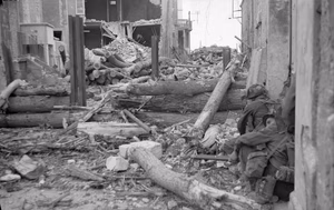 D-day - Allied Forces during the Invasion of Normandy 6 June 1944 Canadian troops of 'B' Company, North Shore (New Brunswick) Regiment, take cover behind steel girders and logs guarding the approach to the German strongpoint WN-27 in St Aubin-sur-Mer, 6 June 1944.