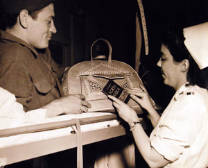80-G-41777: Two hundred and four American patients, taken from USS West Point (AP 23) at Newport News, Virginia, on May 30th, 1943. They came from North Africa along with 2,944 captive Axis soldiers. Private Mason Parker and Lieutenant Viola Heyden review a small pamphlet on North Africa. Photographed May 30, 1943. U.S. Navy Photograph, now in the collections of the National Archives. (2016/05/10).