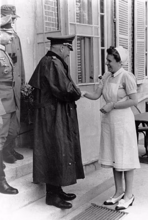 For documentary purposes the German Federal Archive often retained the original image captions , which may be erroneous, biased, obsolete or politically extreme . Generalfeldmarschall von Kluge im Westen Der neuernannte Oberbefehlshaber West, Generalfeldmarschall von Kluge, befand sich in den letzten Tagen auf einer Besichtigungsfahrt an der Kanalküste. Er besuchte die dort eingesetzten Divisionen und informierte sich über den Stand der Verteidigungs- und Abwehrmaßnahmen im Falle einer erneuten Landung des Feindes. Der Generalfeldmarschall, in dessen Begleitung sich ein Divisionskommandeur befindet, verabschiedet sich in einem Soldatenheim von einer DRK-Schwester.