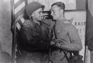 Happy 2nd Lt. William Robertson and Lt. Alexander Silvashko, Red Army, shown in front of sign [East Meets West] symbolizing the historic meeting of the Soviet and American Armies, near Torgau, Germany on w:Elbe Day .