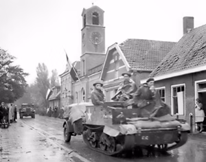 Royal Hamilton Light Infantry carriers move through the Dutch village of Krabbendijke on the Beveland Causeway