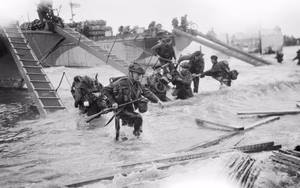 Royal Marine Commandos of headquarters, 4th Special Service Brigade, making their way from onto the 'Nan Red' sector of Juno Beach at St Aubin-sur-Mer, on the morning of 6 June 1944. The British 2nd Army: Royal Marine Commandos of Headquarters, 4th Special Service Brigade, making their way from LCI(S)s (Landing Craft Infantry Small) onto 'Nan Red' Beach, JUNO Area, at St Aubin-sur-Mer at about 9 am on 6 June.