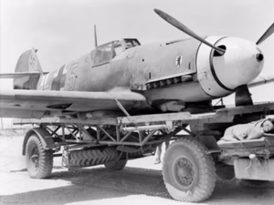 Western Desert, Egypt, 14 August 1942: A captured German Messerschmitt Me 109F ("yellow 5") of 6/JG27 (6th Squadron, 27th Fighter Wing) piloted by Lieutenant Gert Mix which made a forced landing in the rear of the Australian lines near El Alamein is loaded on to a transport to be taken to RAF workashops for examination by experts. Other German planes had tried to destroy this plane after landing in order to prevent expert examination.