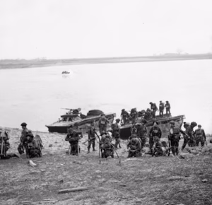 The British Army in North-west Europe 1944-45- Assault on the Rhine and Capture of Wesel This is one of a collection of pictures that show the landing from Buffaloes of the 1st Battalion Cheshire Regiment, who landed on the afternoon of 24th March 1945, in support of No.1 S.S Commando Brigade at Wesel. The bridge seen in background is the smashed railway bridge at Wesel.