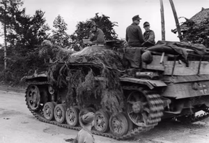 Frankreich.- Invasionsfront, mit Zweigen getarntes Sturmgeschütz III (StuG III) während eines Halts; KBZ OB West — Frankreich
