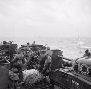 D-day - British Forces during the Invasion of Normandy 6 June 1944 Sherman tanks and other vehicles of 13th/18th Royal Hussars, 27th Armoured Brigade, aboard LCT 610 approaching the French coast, 6 June 1944. The Sherman tank in the foreground (T147161 '10' 'Balaclava') is a RHQ tank. In front of it is a Sherman BARV (Beach Armoured Recovery Vehicle).