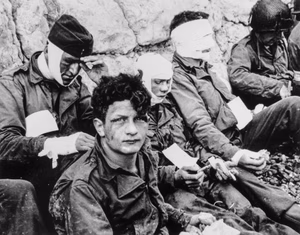 American Assault Troops of the 16th Infantry Regiment, Injured While Storming Omaha Beach, Wait by the Chalk Cliffs for Evacuation to a Field Hospital for Further Medical Treatment, Collville sur Mer, Normandy, France   NARA   531187