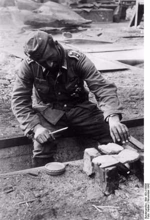 For documentary purposes the German Federal Archive often retained the original image captions , which may be erroneous, biased, obsolete or politically extreme . Russland, Kampf um Stalingrad, Nahrung Scherl: An der Sowjetfront: Grenadiere halten Wacht.- Ein Feldwebel - anscheinen ein Feinschmecker - röstet sich auf einer Feurstelle sein Brot. PK-Aufnahme: Kriegsberichter Herber (Sch) 6550-42 "Fr.f.D.OKW." November 1942 [Herausgabedatum] ADN-Bildarchiv: II. Weltkrieg 1939-45. An der Front in der Sowjetunion; November 1942 Schlacht um Stalingrad: Grenadiere der deutschen Wehrmacht haben in den zerstörten Hallen eines großen Industriebetriebes Stellung bezogen. Ein Feldwebel röstet sich Brot auf einer kleinen Feuerstelle. [Sowjetunion.- Schlacht um Stalingrad]