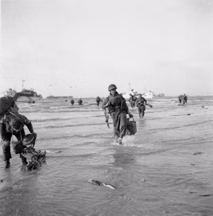 D-day - British Forces during the Invasion of Normandy 6 June 1944 Beach Group troops wade ashore from landing craft on Queen beach, Sword area, on the evening of 6 June 1944.