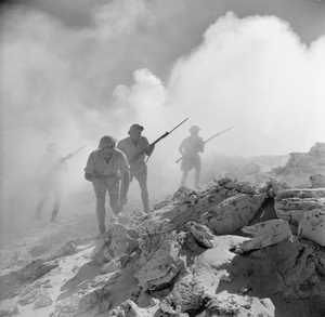 Campaign in North Africa 1940 - 1943 'Australians storm a strongpoint'. A posed portrait of Australian troops advancing during the Second Battle of El Alamein, 3 September 1942.