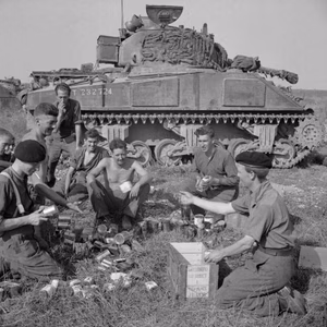 The crew of a Sherman tank of 1st Northamptonshire Yeomanry receive rations before the start of Operation 'Totalise' ,