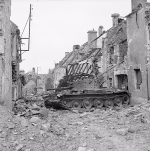 Knocked-out Cromwell observation post tank, commanded by Captain Paddy Victory of 5th Royal Horse Artillery, 7th Armoured Division, in Villers-Bocage, 5 August 1944. Captain Victory had attempted to do a neutral turn to escape more quickly, however a loose large paving slab jammed the track and essentially immobilised the tank. [ 1 ]