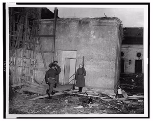 An American army officer salutes as he enters Adolf Hitler's bunker at the Chancellory, Berlin, Germany, where two Russian soldiers stand guard — Bunkers--Germany--Berlin--1940-1950. Government facilities--Germany--Berlin--1940-1950. War damage--Germany--Berlin--1940-1950. World War, 1939-1945--Destruction & pillage--Germany--Berlin. Photographic prints--1940-1950. — 1945 July 10.