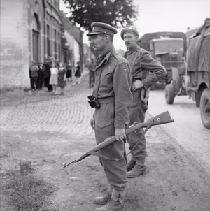 The British Army in North-west Europe 1944-45 Major Stewart Fotheringham and CSM Low of 'X' Company Scots Guards (under command of 1st Welsh Guards) watch mopping up operations during the advance on Brussels, 4 September 1944. The Major is carrying a German KAR 98 rifle.