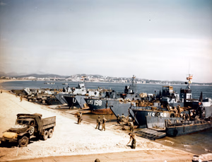 Invasion of Southern France, August 1944. LCTs and LCMs landing supplies on the beach of Fréjus, on "D" plus five, 20 August 1944. LCTs present include LCT-198 and LCT-559. Matted ramp in foreground is for DUKW Amphibious Trucks.