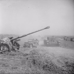 A Cromwell tank and jeep pass an abandoned German PAK 43/41 gun during Operation 'Totalise' .
