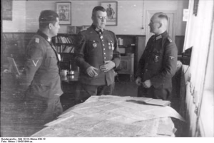 Drei SS-Offiziere bei Besprechung vor Kartentisch. vlnr: SS-Brigadeführer und General-Major der Waffen-SS, SS-Obergruppenführer und General der Waffen-SS Erich von dem Bach-Zelewski (Mitte; mit Orden Deutsches Kreuz in Gold, verliehen am 23.02.1943, ohn