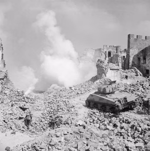 A Sherman tank of 19th Armoured Regiment, 4th New Zealand Armoured Brigade supporting infantry of 6th NZ Infantry Brigade, during a reconstruction of the action at Cassino, Italy, 8 April 1944. A Sherman tank of 19th Armoured Regiment, 4th New Zealand Armoured Brigade supports infantry of 24th Battalion, 6th NZ Infantry Brigade, during a reconstruction of recent action in Cassino, 8 April 1944.