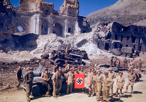British and South African soldiers hold up a Nazi trophy flag while combat engineers on bulldozers clear a path through the debris of the bombed out city of Cassino in 1944. ww2colorfarbe.blogspot.com : British and South African soldiers show off a prize, a swastika Nazi flag, after finally conquering Monte Cassino, 18 May 1944. By May 1944 the historic Benedictine Abbey of Monte Cassino had been reduced to rubble. As part of Operation Diadem, the task of capturing it was given to Polish II Corps, but their attack on the night of May 11th/12th failed. The German positions in and around the ruins high on the mountain (atop which the soldiers above are standing on) were simply too strong. Further to the south, however, French troops managed to find a way through the Aurunci Mountains, which the German's believed are impassable, and could now overlook the Liri Valley, through which highway 6 ran to Rome. A second attack on Monte Cassini by the Poles, on May 17th, made some progress, but because of the French advance German troops were already withdrawing from the Gustav Line. The following morning the Polish flag was hoisted over the ruins of the abbey. The capture of Monte Cassino came at a high price. The Allies suffered around 55,000 casualties in the Monte Cassino campaign. German casualty figures are estimated at around 20,000 killed and wounded. Total Allied casualties, spanning the period of the four Cassino battles and the Anzio campaign with the subsequent capture of Rome on 5 June 1944, were over 105,000. This image is in beautiful and original Kodachrome, and was taken by Carl Mydans (2007–2004) from LIFE magazine.